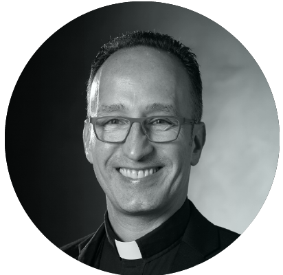 Man wearing glasses and a clerical collar.